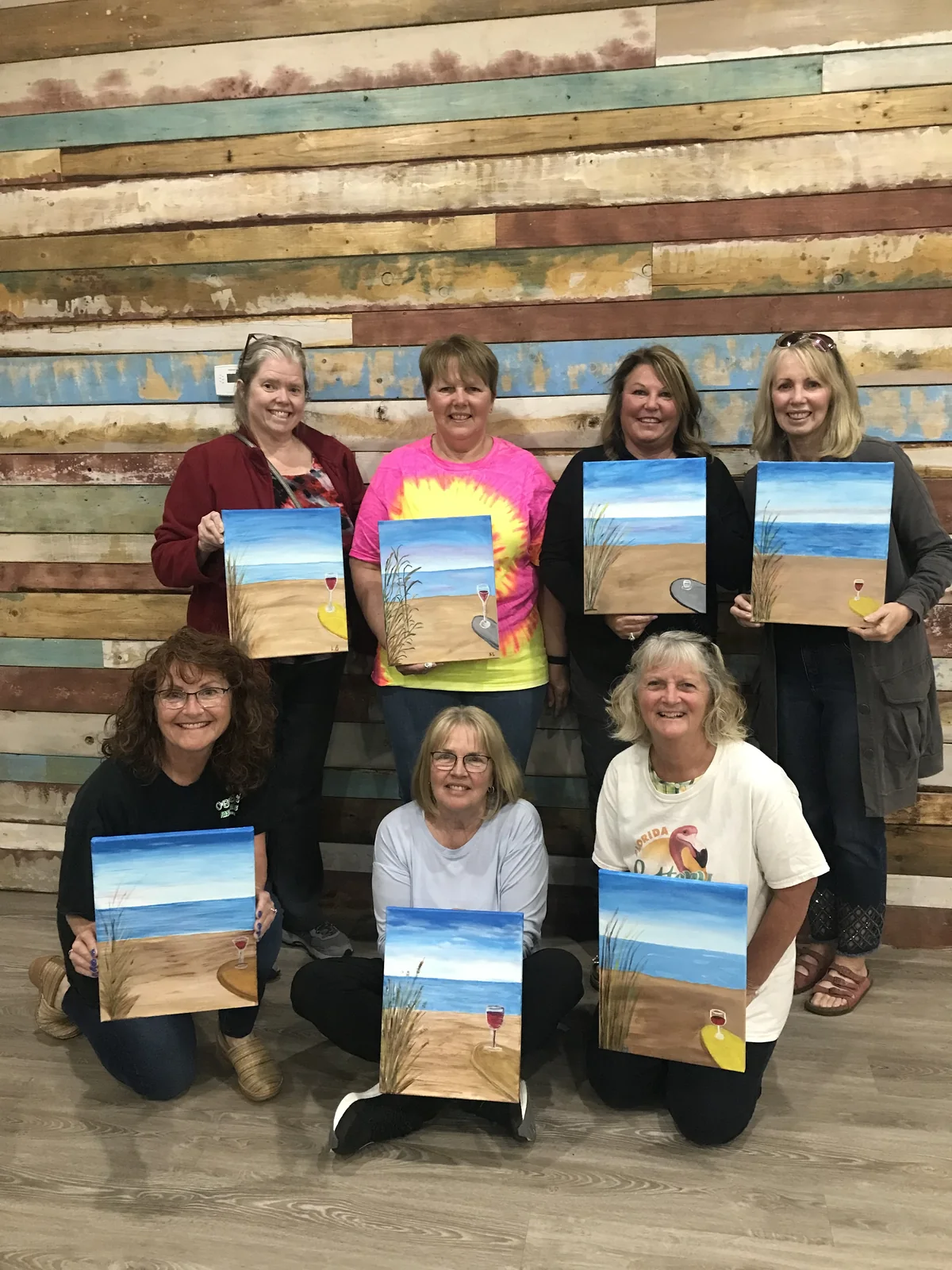 A paint party group showing their finished paintings